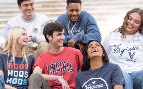 A group of people sitting on the Rotunda steps in Red, White and Hoo gear